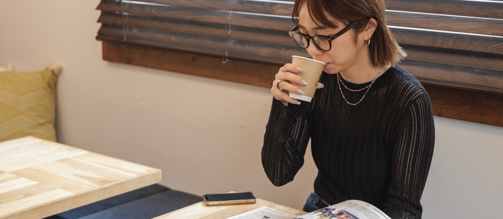 コーヒーを飲みながら読書する女性